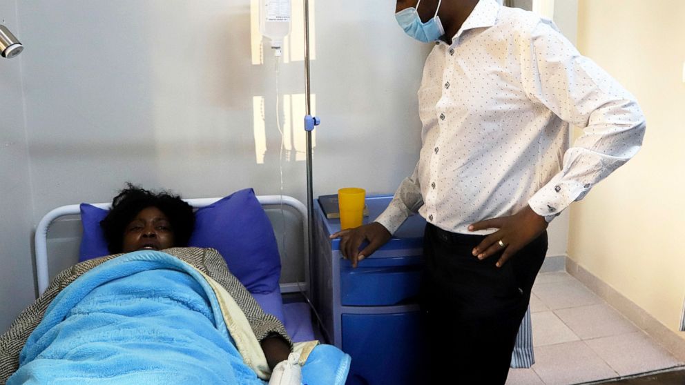 Zimbabwean opposition leader Nelson Chamisa, right, visits an activist who was reported missing, at a local hospital in Harare, Friday, May 15, 2020. Three young Zimbabwean opposition activists who were reported missing following a protest over COVID