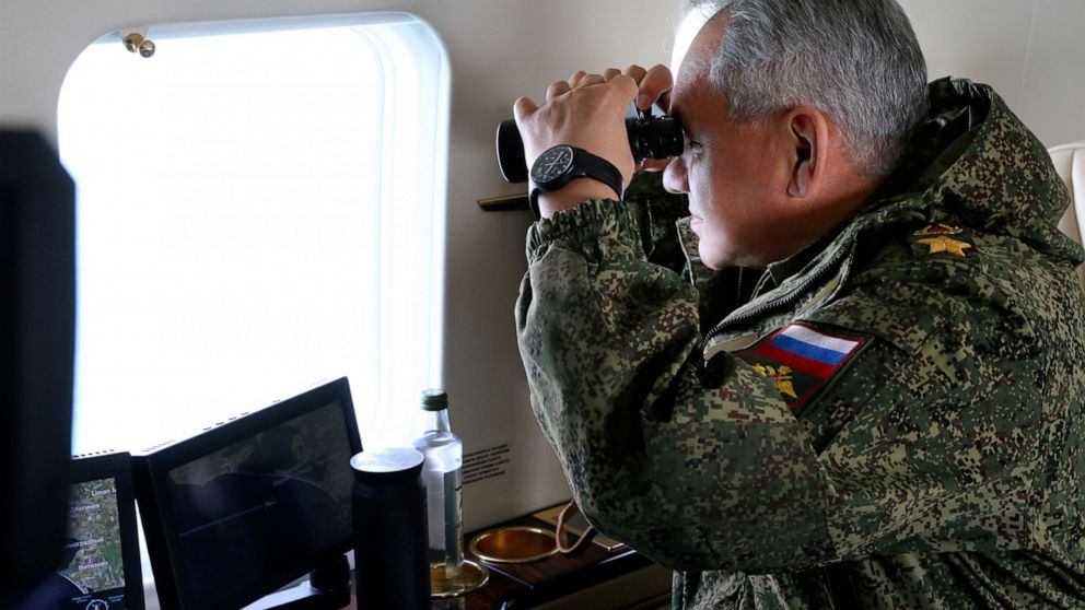 This handout photo released on Thursday, April 22, 2021 by the Russian Defense Ministry Press Service shows, Russian Defense Minister Sergei Shoigu watches drills form a board of military helicopter in Crimea. The Russian military is conducting massi