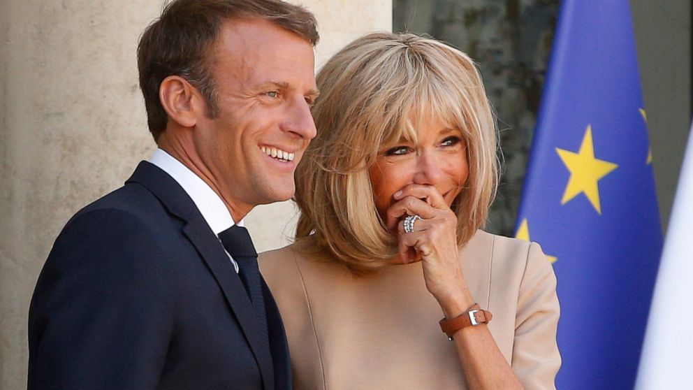 FILE - In this Thursday, Aug. 22, 2019 file photo, French President Emmanuel Macron, and his wife Brigitte, share a laugh as they wait for Greece's Prime Minister Kyriakos Mitsotakis at the Elysee Palace, in Paris. World leaders have offered support 