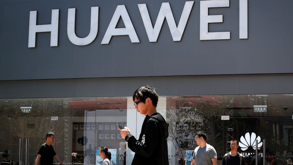 People walk past a Huawei retail store in Beijing, Sunday, June 30, 2019. Once again, Presidents Donald Trump and Xi Jinping have hit the reset button in trade talks between the world's two biggest economies, at least delaying an escalation in tensio