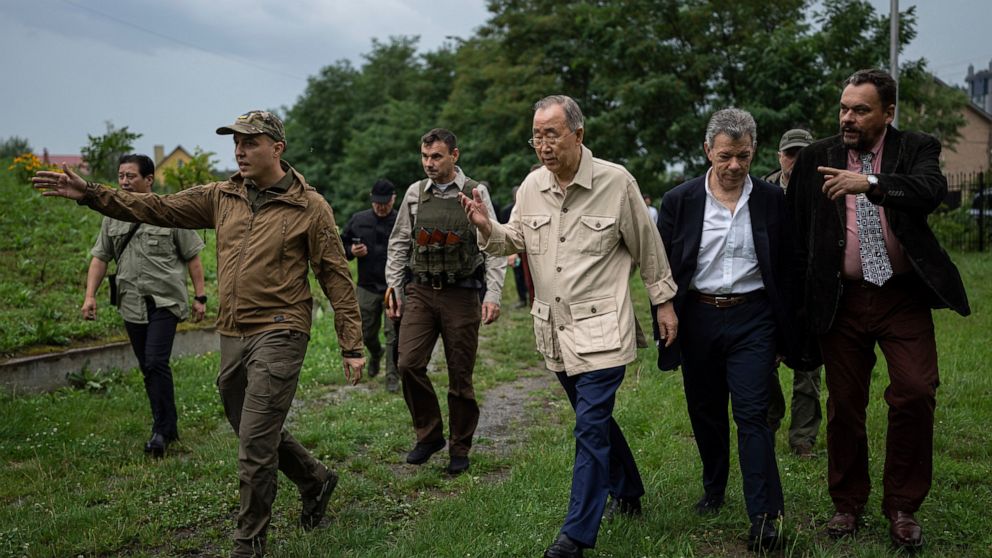 Former U.N. Secretary-General Ban Ki-moon, centre, and former Colombia's President Juan Manuel Santos, centre right, walk during their visit in Bucha near Kyiv, Ukraine, Tuesday, Aug. 16, 2022. The former leader of the United Nations called on the wo
