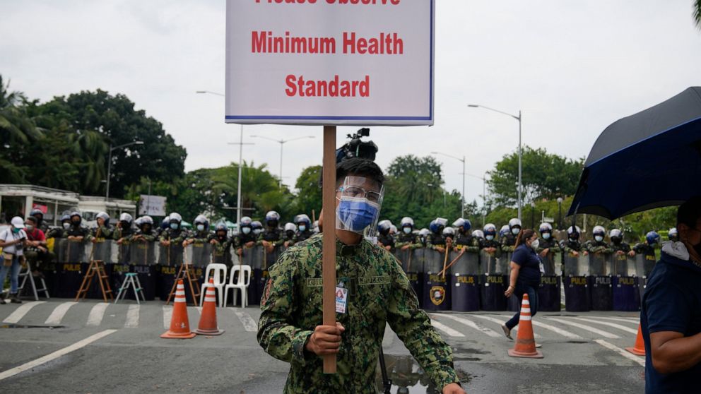 A policeman walks with a sign as they secure an area where politicians file their certificates of candidacy at the Commission on Elections at the Sofitel Harbor Garden Tent in Metropolitan Manila, Philippines on Monday Oct. 4, 2021. Politicians conti