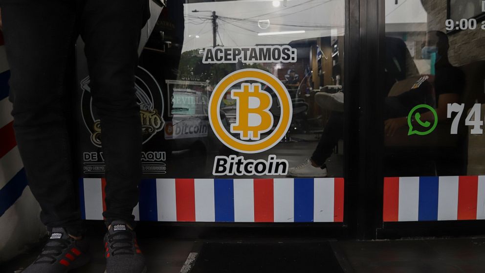 FILE - "We accept Bitcoin" is announced at a barber shop in Santa Tecla, El Salvador, Sept. 4, 2021. The IMF urged the government of El Salvador on Tuesday, Jan. 25, 2022 to eliminate Bitcoin as legal tender. (AP Photo/Salvador Melendez, File)