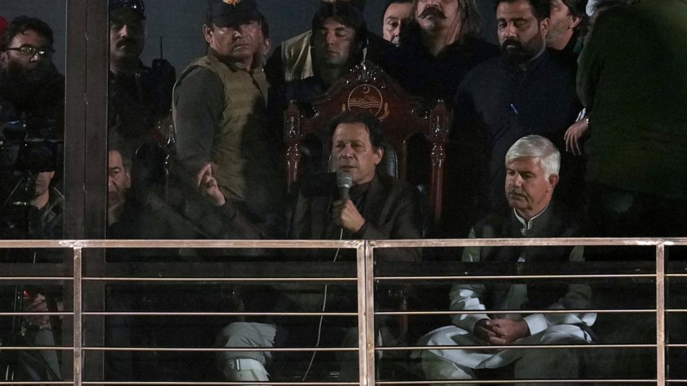 Pakistan's former Prime Minister and opposition leader Imran Khan, center in seated, addresses to his supporters during a rally, in Rawalpindi, Pakistan, Saturday, Nov. 26, 2022. Khan said Saturday his party was quitting the country's regional and na