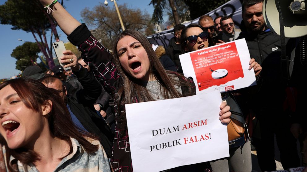 A protester holing a banner that reads "We want free public education," shouts slogans during an anti-government rally in Tirana, Albania, Saturday, March 12, 2022. Thousands of Albanians are holding on Saturday a protest in the capital Tirana agains