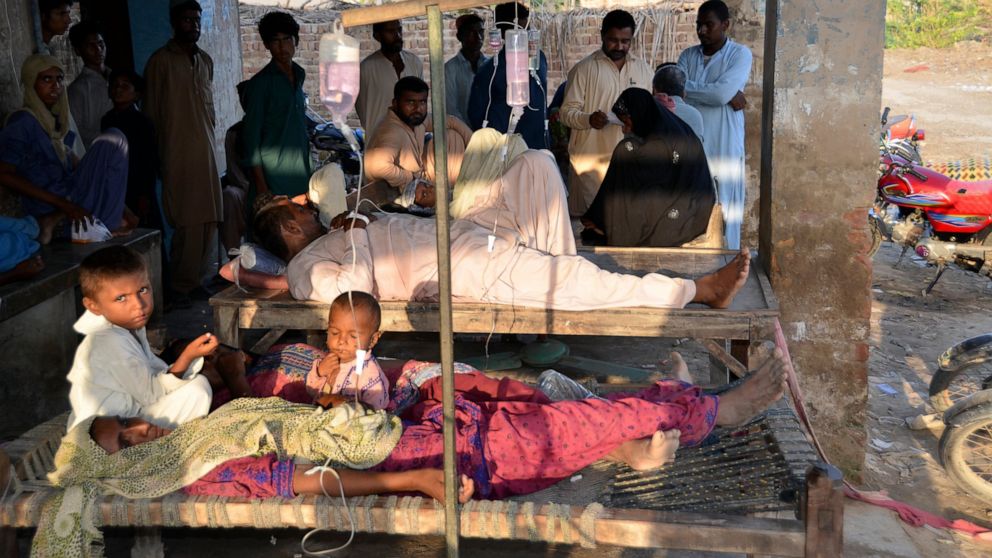 People receive treatment at a temporary medical center in Jaffarabad, a flood-hit district of Baluchistan province, Pakistan, Monday, Sept. 19, 2022. Pakistan said Monday there have been no fatalities for the past three days from the deadly floods th