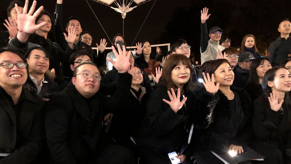 In this Tuesday, Dec. 10, 2019 photo, members of a theater troupe raise their hands to symbolize the five demands of pro-democracy protesters after a performance of Les Miserables in at an outdoor event space in Hong Kong. A Hong Kong theater troupe 