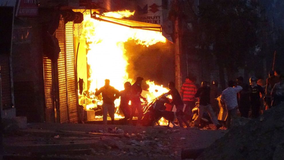 FILE - In this Tuesday, Feb. 25, 2020, file photo, a shop burns after it was set on fire by a mob in New Delhi, India. Indian police violated human rights during deadly religious riots in New Delhi earlier this year, Amnesty International said in a r