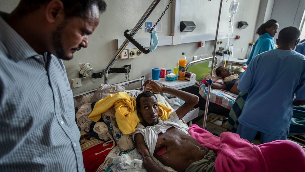 FILE - In this Thursday, May 6, 2021 file photo, a farmer Teklemariam Gebremichael, who said he was shot by Eritrean forces in Enticho six months before and is still recovering, speaks to a doctor, left, at the Ayder Referral Hospital in Mekele, in t