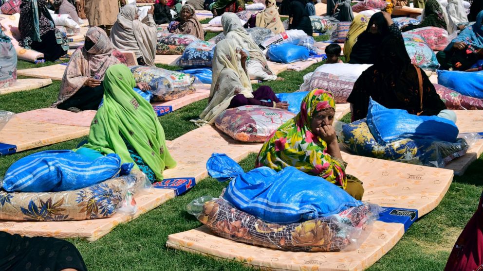 Victims of heavy flooding from monsoon rains receive relief aid provided by the Allah-o-Akbar Tehreek political party, in Quetta, Pakistan, Sunday, Sept. 11, 2022. Since June, heavy rains and flooding have added a new level of grief to cash-strapped 