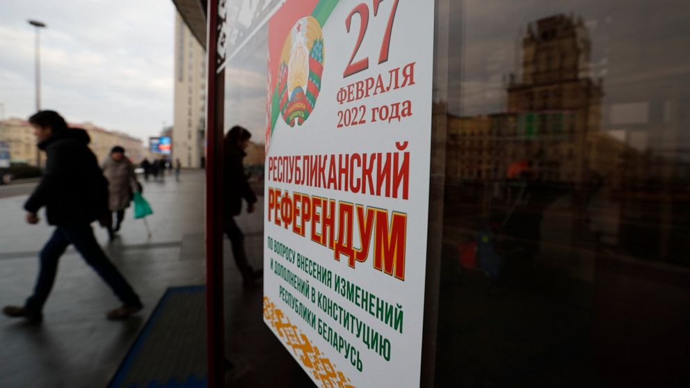 People walk past a poster which reads "Referendum on constitutional amendments" in Minsk, Belarus, Wednesday, Feb. 16, 2022. Belarusians vote at a referendum on constitutional amendments that could allow country's strongman Alexander Lukashenko to fu