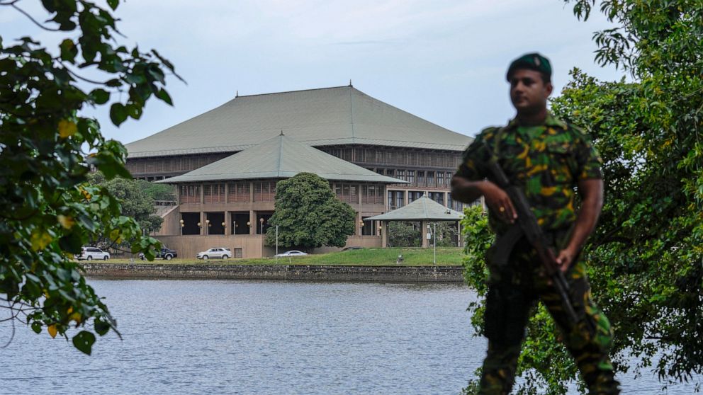 FILE- An army soldier soldier stands guard outside the parliament building in Colombo, Sri Lanka, Saturday, July 16, 2022. Sri Lankan lawmakers began debating a proposed constitutional amendment on Thursday that would trim the powers of the president