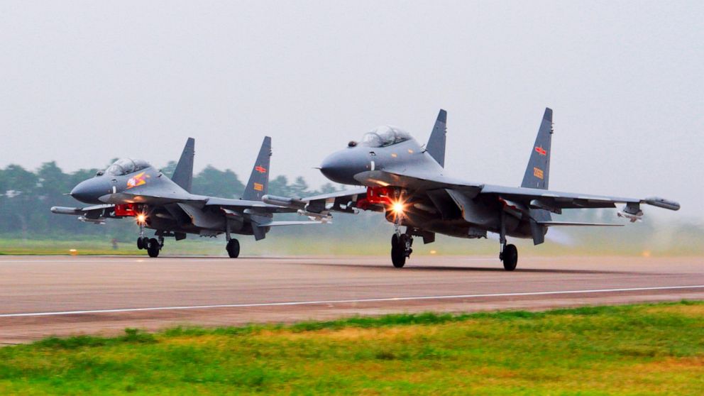 FILE - In this undated file photo released by China's Xinhua News Agency, two Chinese SU-30 fighter jets take off from an unspecified location to fly a patrol over the South China Sea. China flew more than 30 military planes, including SU-30 fighter 