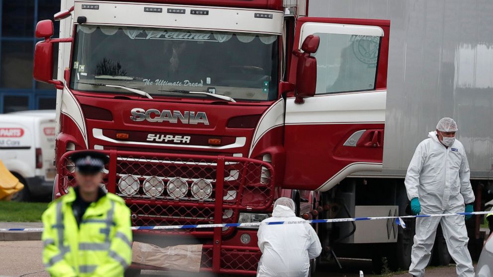 FILE - In this Wednesday Oct. 23, 2019 file photo, forensic police officers attend the scene after a truck was found to contain a large number of dead bodies, in Grays, South England. A truck driver accused in the deaths of 39 Vietnamese migrants who