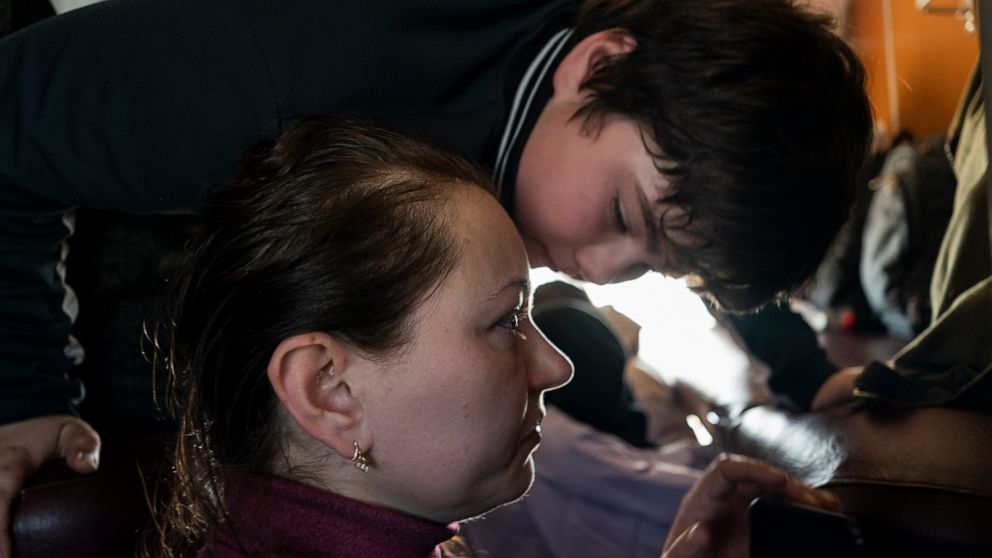 Marina Galla and her son, who both scaped from the besieged city of Mariupol onboard a Zaporizhzhia-Lviv train in western Ukraine, on Sunday, March 20, 2022. (AP Photo/Bernat Armangue)