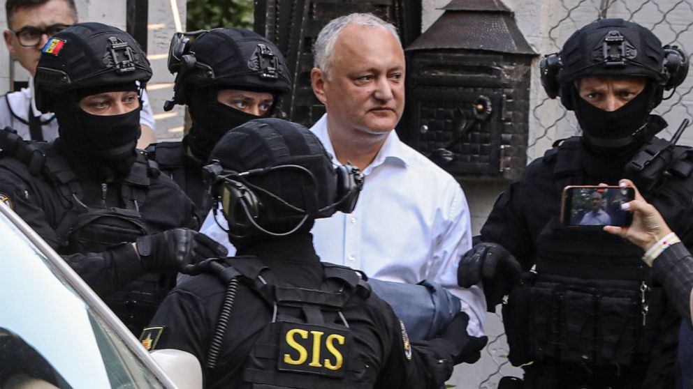 FILE - Members of Moldova's Information and Security service (SIS) escort former Moldovan President Igor Dodon to a van after he was detained at his house in Chisinau, Moldova, May 24, 2022. A court in Moldova has placed former President Igor Dodon u