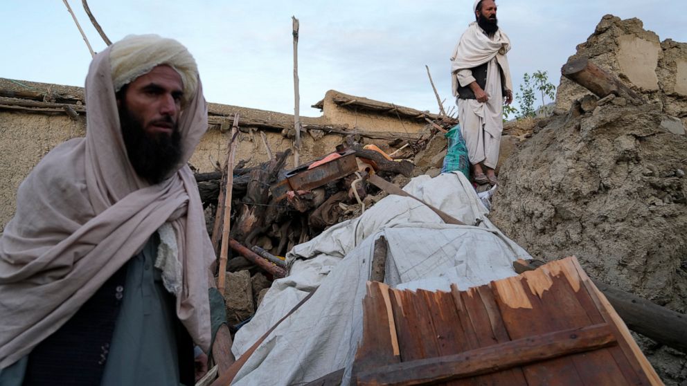Afghans stand among destruction after an earthquake in Gayan village, in Paktika province, Afghanistan, Thursday, June 23, 2022. A powerful earthquake struck a rugged, mountainous region of eastern Afghanistan early Wednesday, flattening stone and mu