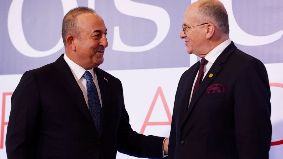 Polish Minister of Foreign Affairs Zbigniew Rau, right, welcomes his Turkish counterpart Mevlut Cavusoglu , left, during a high-level meeting of the Organization for Security and Cooperation in Europe in Lodz, Poland, Thursday, Dec. 1, 2022. The OSCE