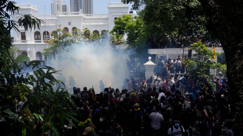 Police use teargas as Sri Lankan protesters storm prime minister Ranil Wickremesinghe 's office, demanding he resign after president Gotabaya Rajapaksa fled amid economic crisis in Colombo, Sri Lanka, Wednesday, July 13, 2022. (AP Photo/Rafiq Maqbool)