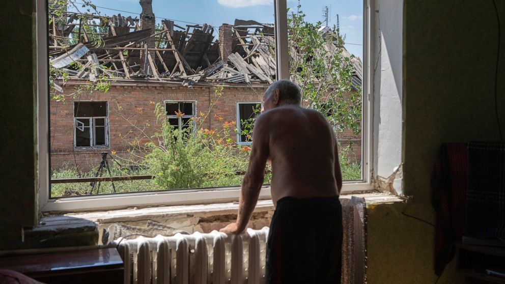 Victor Rosenberg, 81, looks out of a broken window in his home destroyed by the Russian rocket attack in the city centre of Bakhmut, Donetsk region, Ukraine, Friday, July 1, 2022. (AP Photo/Efrem Lukatsky)