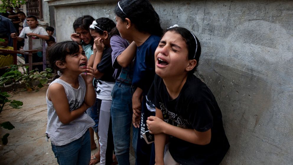 Mourners react during the funeral of Palestinian Tamim Hijazi, who was killed in an Israeli air strike, in Khan Yunis in the southern Gaza Strip, Saturday, Aug. 6, 2022. Israeli jets pounded militant targets in Gaza as rockets rained on southern Isra