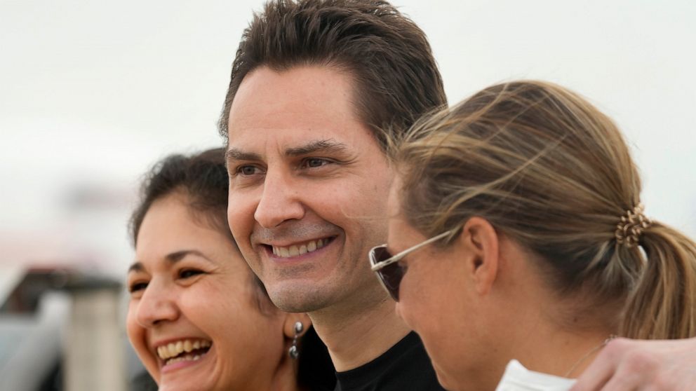 Michael Kovrig, centre, embraces his wife Vina Nadjibulla, left, and sister Ariana Botha after arriving at Pearson International Airport in Toronto, Saturday, Sept. 25, 2021. China, the U.S. and Canada completed a high-stakes prisoner swap Saturday w