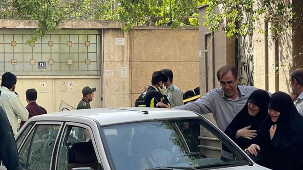 In this photo provided by Islamic Republic News Agency, IRNA, family members of Col. Hassan Sayyad Khodaei weep over his body at his car after being shot by two assailants in Tehran, Iran, Sunday, May 22, 2022. Hassan Sayyad Khodaei, a senior member 