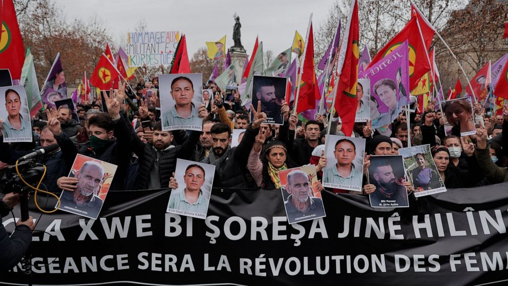 Kurdish activist and anti-racism group stage a protest holding Kurdistan Workers Party, PKK, flag and pictures of the recent victimes of the shooting at the Kurdish culture center in Paris, Saturday, Dec. 24, 2022. Kurdish activists, left-wing politi