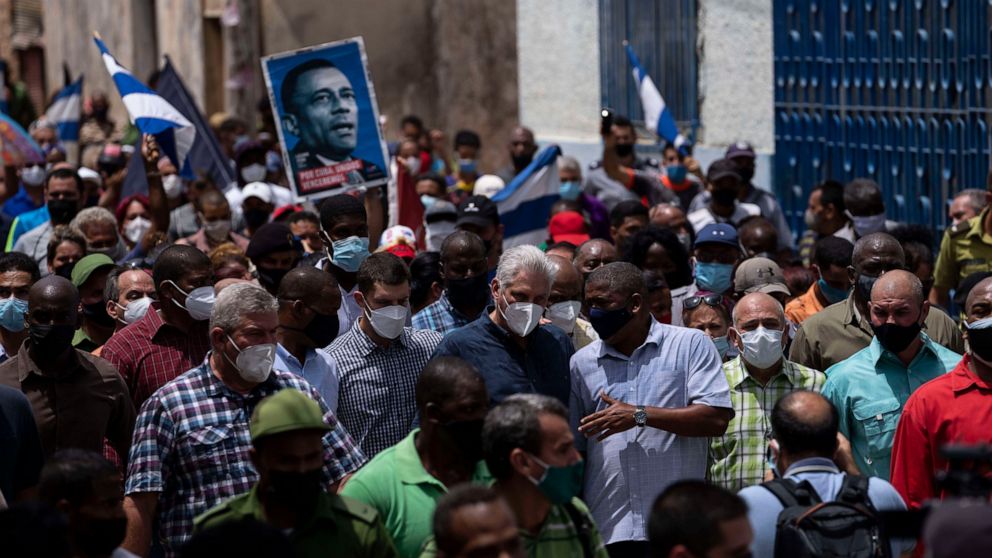 Cuba's President Miguel Diaz Canel walks with his followers after an anti-government protest in San Antonio de los Banos, Cuba, Sunday July 11, 2021. Hundreds of demonstrators went out to the streets in several cities in Cuba to protest against ongoi