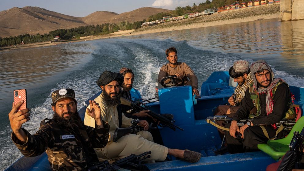 Taliban fighters enjoy a boat ride in the Qargha dam, outskirt of Kabul, Afghanistan, Friday, Sept. 24, 2021. (AP Photo/Bernat Armangue)
