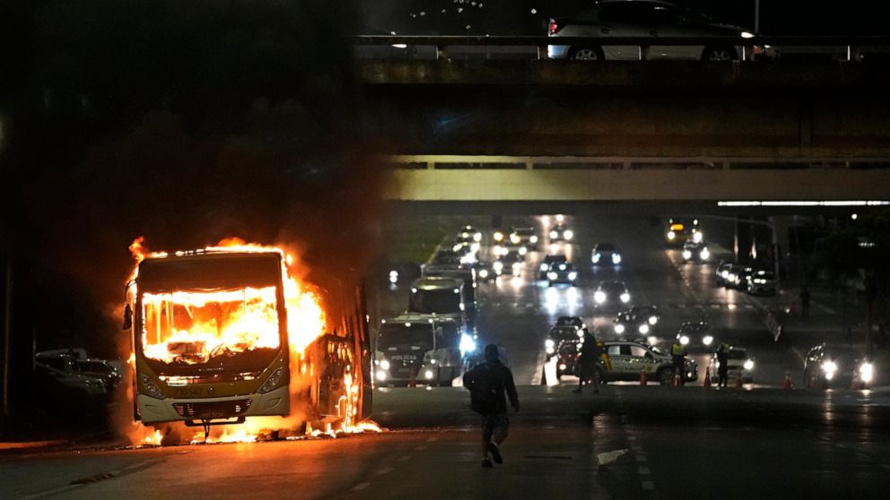 Supporters of Brazilian President Jair Bolsonaro clash with police setting fire to several vehicles and allegedly trying to storm the headquarters of the Federal Police in Brasilia, Brazil, Monday, Dec. 12, 2022. Since Bolsonaro lost re-election to L