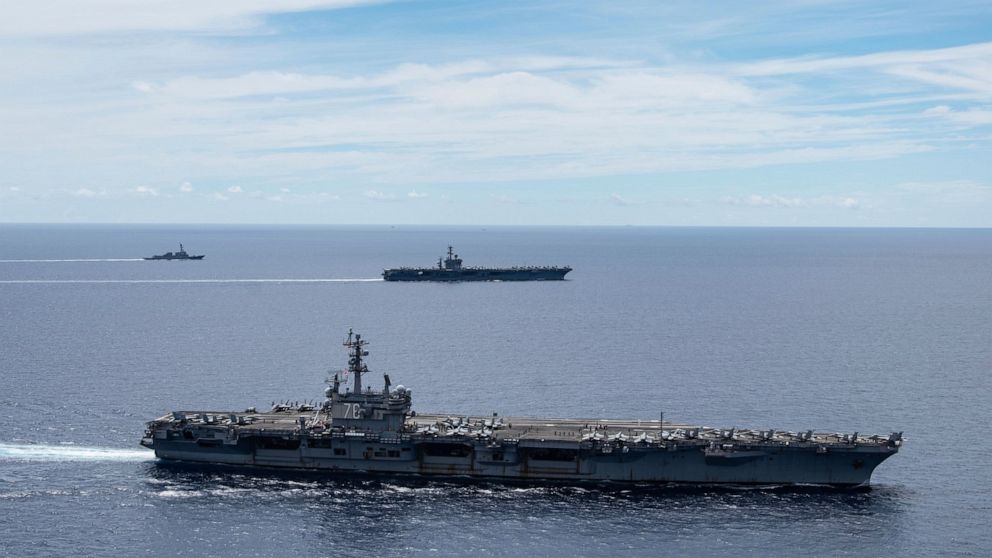 FILE - In this July 6, 2020, file photo provided by U.S. Navy, the USS Ronald Reagan (CVN 76, front) and USS Nimitz (CVN 68, rear) Carrier Strike Groups sail together in formation, in the South China Sea. The U.S. Navy says the aircraft carrier Ronal