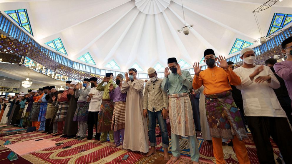 Muslims wearing protective masks pray at National Mosque in the morning of the Eid al-Fitr, marking the end the holy fasting month of Ramadan, in Kuala Lumpur, Malaysia, Monday, May 2, 2022. (AP Photo/Vincent Thian)