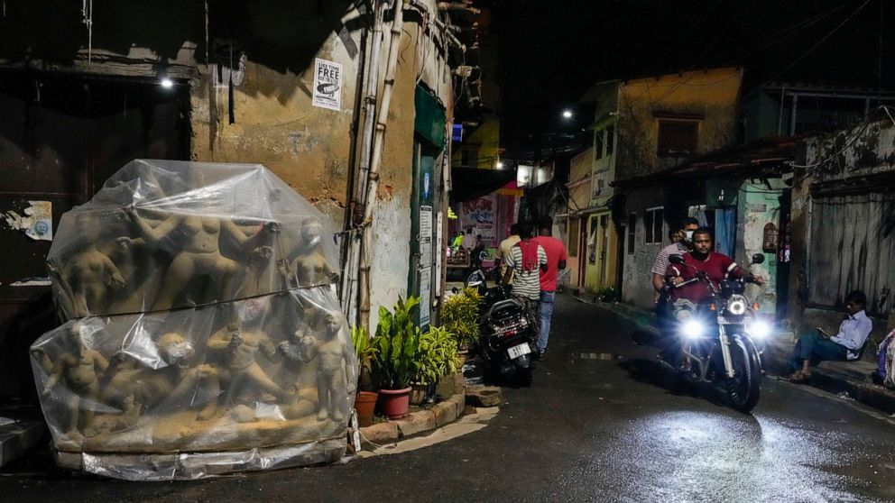 An unfinished clay idol of Hindu goddess Durga is wrapped with plastic sheet on a roadside temporary studio to protect it from the rain, ahead of Hindu festival Durga Puja at Kumortuli, the potters' place, in Kolkata, India, Sept. 11, 2022. The five-