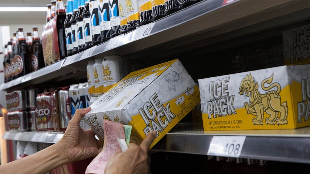 In this Thursday, April 9, 2020, photo, a customer shops for beer at a superstore in Bangkok, Thailand, a day ahead of a ban on sales of alcoholic beverages. Thailand's capital city on Friday began an 11-day sales ban to discourage drinking parties w