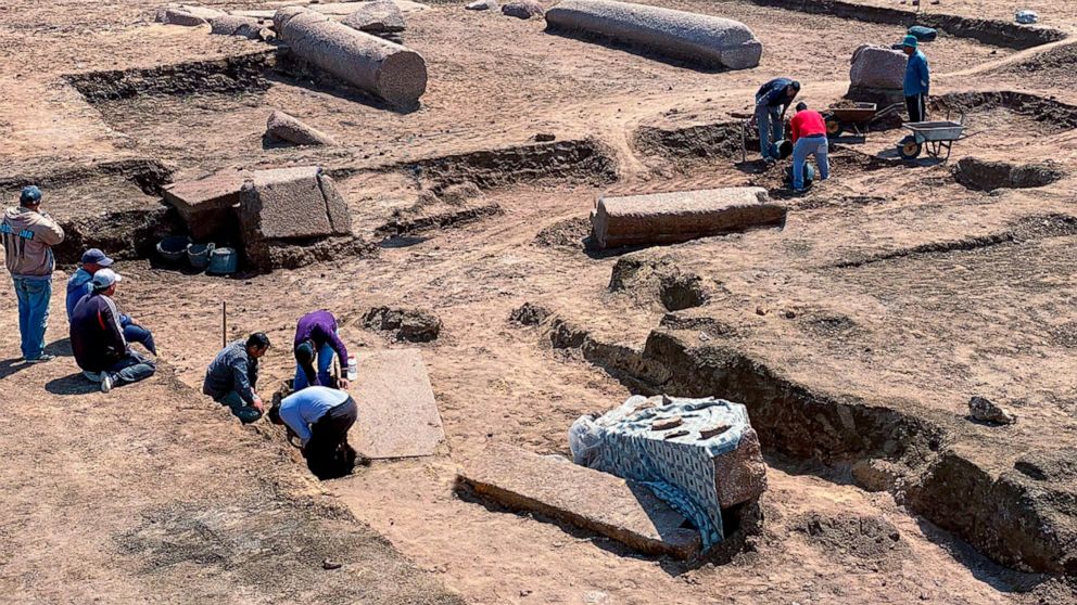 This undated photo provided by the Egyptian Tourism and Antiquities Ministry on Monday, April 25, 2022, shows archeologists working in the ruins of a temple for Zeus-Kasios, the ancient Greek god, at the Tell el-Farma archaeological site in the north