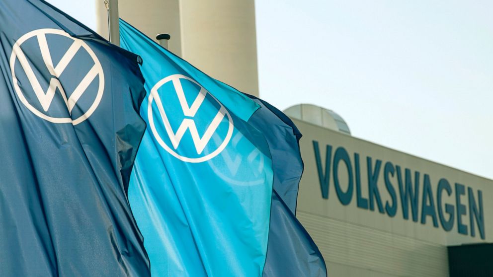 FILE - In this file photo dated April 23, 2020, company logo flags wave in front of a Volkswagen factory building in Zwickau, Germany. Volkswagen has set the price range for the multibillion-euro sale of a minority stake in luxury brand Porsche as it