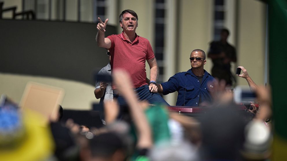 Brazil's President Jair Bolsonaro speaks to supporters during a protest in front the army's headquarters during the Army day, amid the new coronavirus pandemic, in Brasilia, Brazil, Sunday, April 19, 2020. Bolsonaro came out in support of a small pro