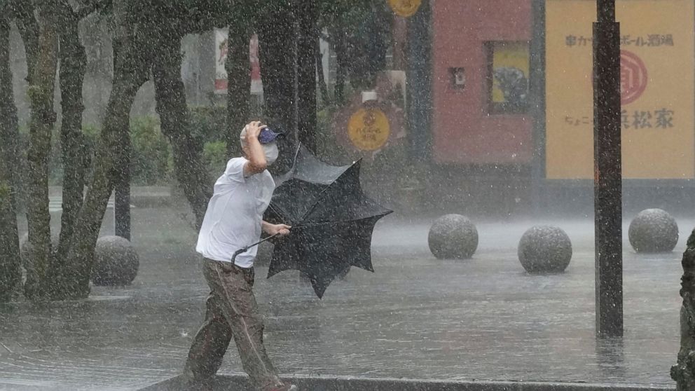 A man is drenched by the rain brought by Tropical Storm Meari, in Hamamatsu...