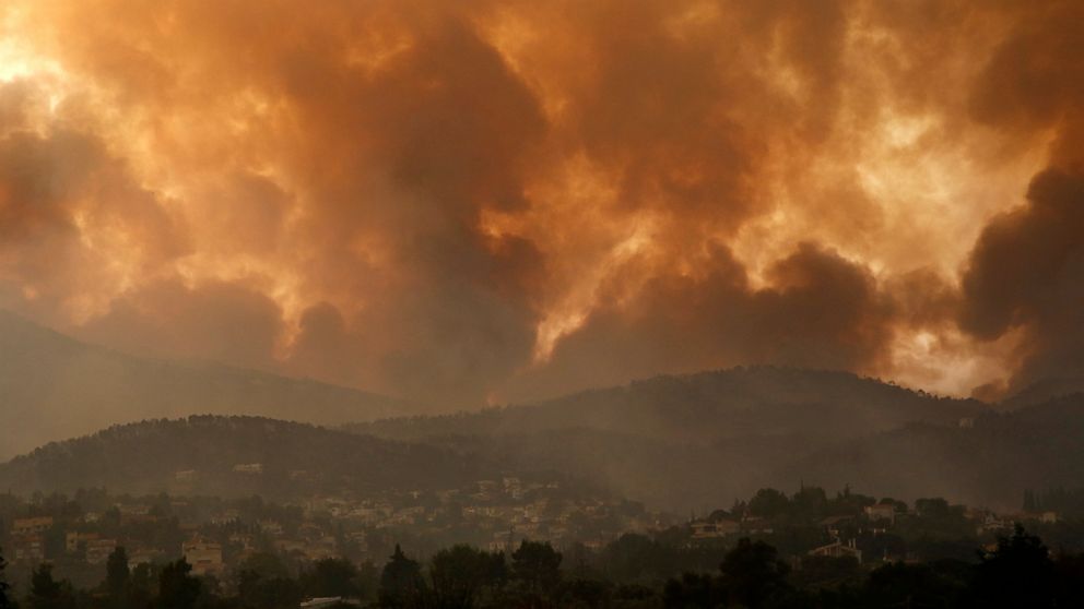 Smoke spreads over Parnitha mountain during a wildfire in Ippokratios Politia village, about 35 kilometres (21 miles), northern Athens, Greece, Friday, Aug. 6, 2021. Thousands of people fled wildfires burning out of control in Greece and Turkey on Fr