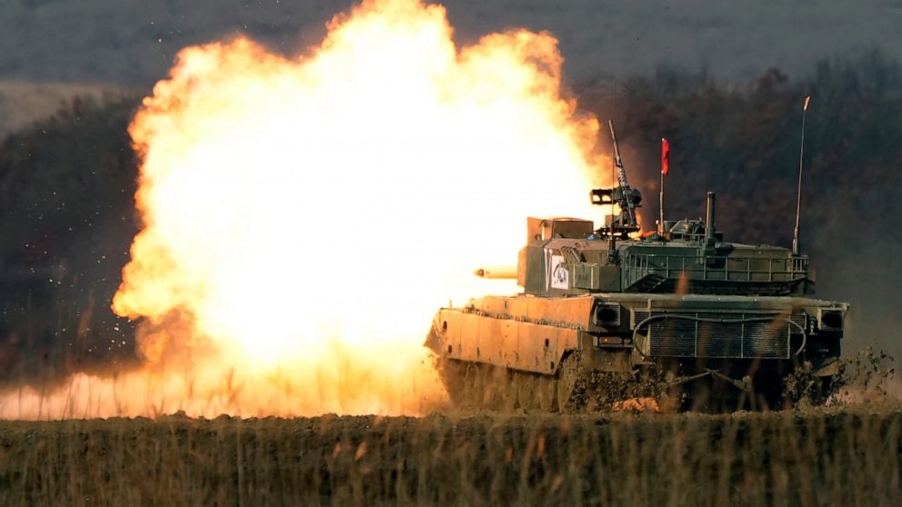 FILE - A Japanese Ground-Self Defense Force (JGDDF) Type 90 tank fires its gun while advancing towards a target during an annual exercise at the Minami Eniwa Camp Tuesday, Dec. 7, 2021, in Eniwa, Japan's northern island of Hokkaido. Japan's Defense M