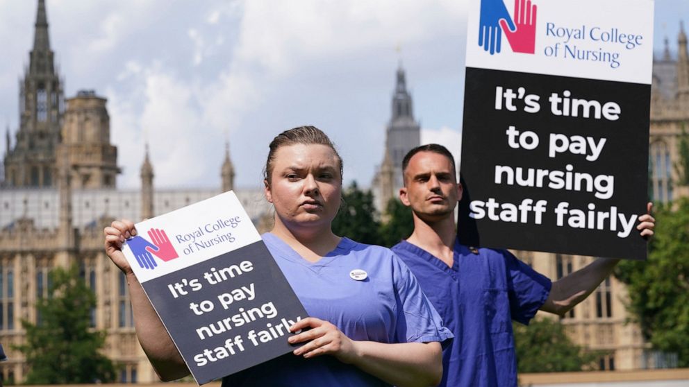 Nurses hold placards outside the Royal College of Nursing (RCN) in Victoria Tower Gardens, London, Wednesday July 21, 2021. In a statement Wednesday July 21, 2021, the British government has tripled its pay increase offer for more than a million Nati
