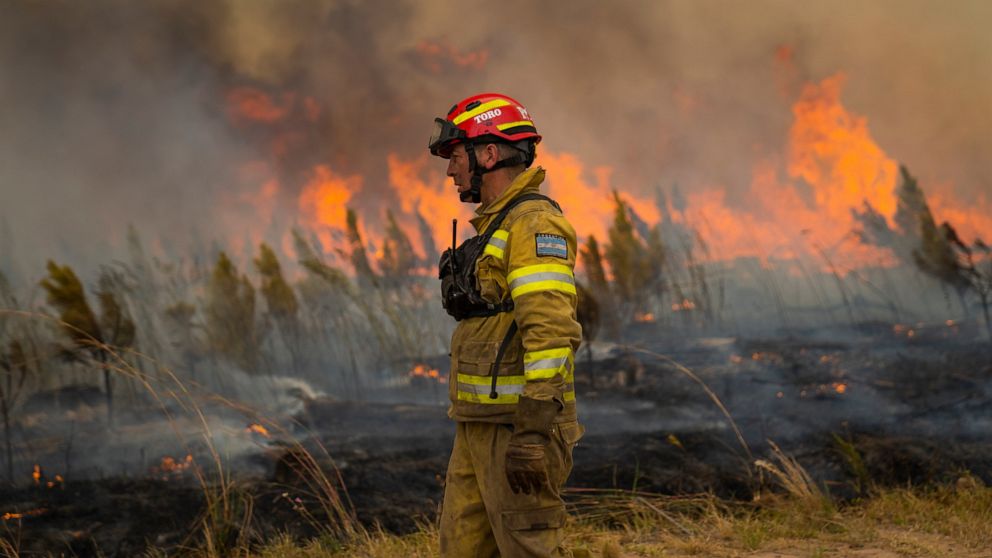 A firefighter works to extinguish a brush fire in Santa Tecla, Corrientes province, Argentina, Sunday, Feb. 20, 2022. Fires continue to ravage the Corrientes province that has burnt over half-a-million hectares. (AP Photo/Rodrigo Abd)