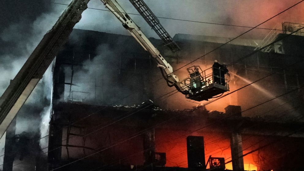 Fire officials try to douse a fire in a four storied building, in New Delhi, India, Friday, May 13, 2022. A massive fire erupted in a four-storied building in the Indian capital on Friday, killing at least 19 people and leaving several injured, the f