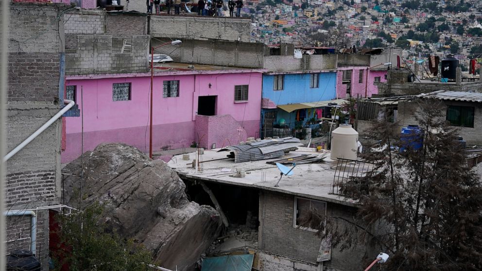A boulder that plunged from a mountainside rests among homes in Tlalnepantla, on the outskirts of Mexico City, when a mountain gave way on Friday, Sept. 10, 2021. A section of mountain on the outskirts of Mexico City gave way Friday, plunging rocks t