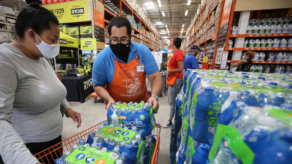 Home Depot department supervisor, Arnaldo Gonzalez, loads water bottles into Elena Arvalo's shopping cart as shoppers prepare for possible effects of tropical storm Elsa in Miami on Saturday, July 3, 2021. Elsa fell back to tropical storm force as it