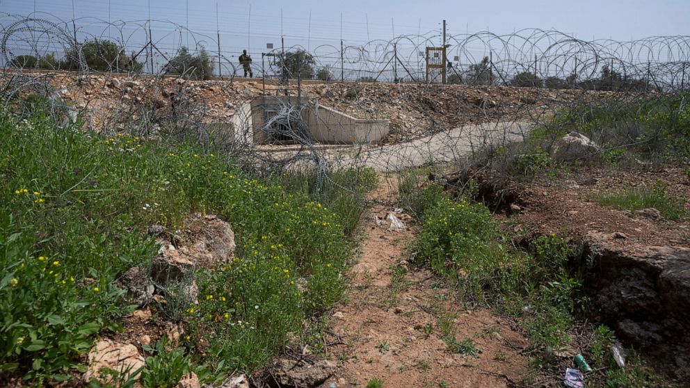 An Israeli soldier guards an opening in Israel's West Bank separation barrier that was reinforced with barbed wire to prevent Palestinians from crossing into Israel, in the West Bank village of Nilin, west of Ramallah, Sunday, April 10, 2022. Israel 