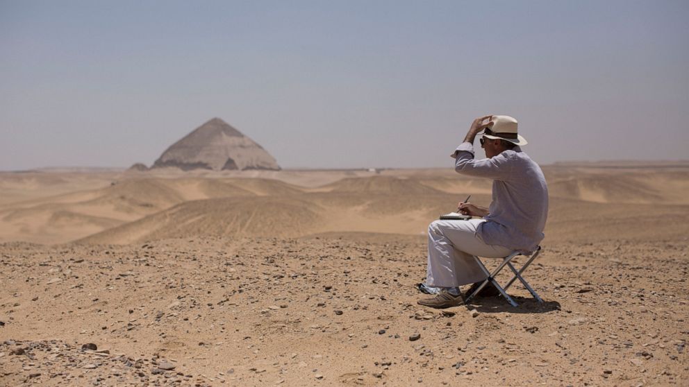 A member of an international delegation sketches the site of the Bent Pyramid during an event opening the pyramid and its satellites for visitors in Dashur, Egypt, Saturday, July 13, 2019. The Bent pyramid, listed on UNESCO's world heritage list as p