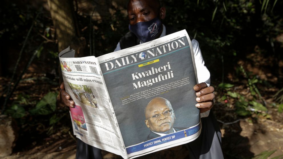 A man reads a copy of the Daily Nation morning newspaper reporting the death of neighboring Tanzania's President John Magufuli on a street in Nairobi, Kenya Thursday, March 18, 2021. Magufuli, a prominent COVID-19 skeptic whose populist rule often ca