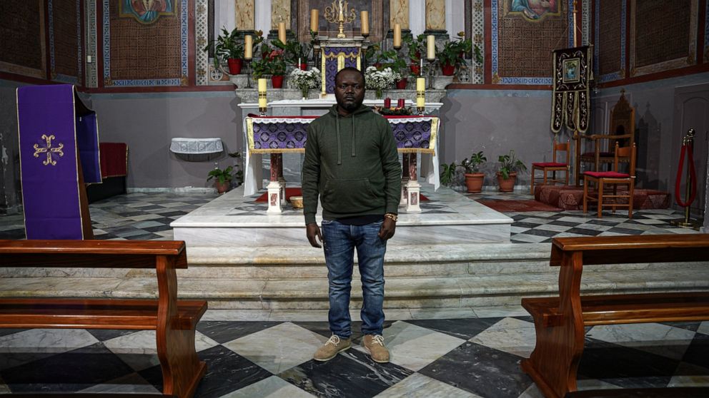 Christian Tango Muyaka, a 30-year-old asylum-seeker from Congo, poses for a photograph inside a Catholic church in Mytilene port, on the northeastern Aegean island of Lesbos, Greece, Monday, Nov. 29, 2021. Muyaka will attend a Sunday service held by 